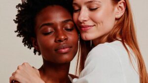 Mulheres lésbicas se abraçando com afeto, representando apoio emocional ao sair do armário.