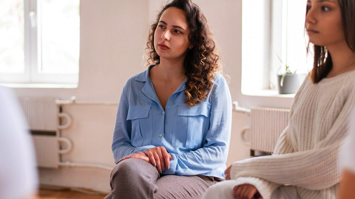 Mulheres participando de uma sessão terapêutica em ambiente acolhedor, simbolizando atendimento psicológico especializado para lésbicas.