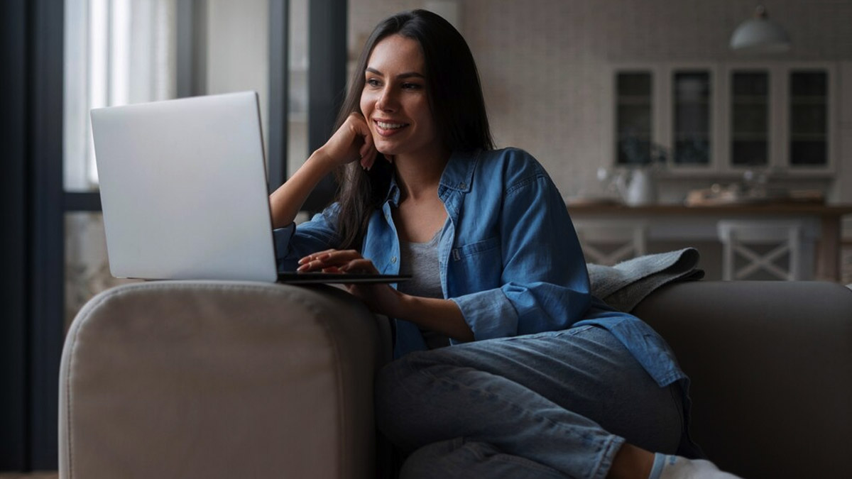 Mulher sorrindo enquanto participa de uma sessão de terapia online em casa, simbolizando terapia lésbica online.